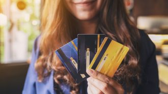 Closeup image of a woman holding and showing credit card